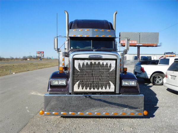 Front view of a blue semi truck with a customized grille featuring a Semi Bug Screen: Jaws design.