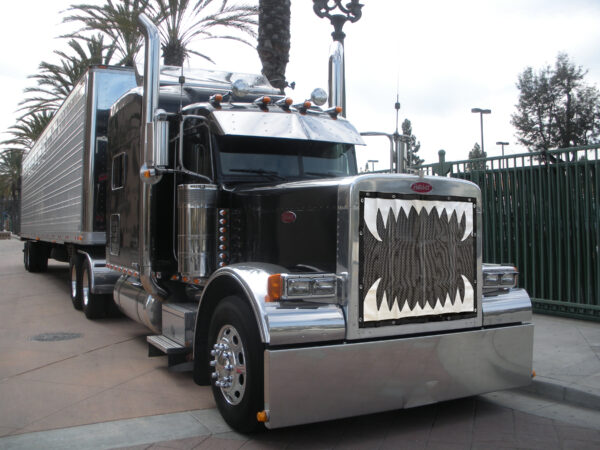 A shiny black Jaws Bug Screen semi-truck with chrome detailing parked on a street.