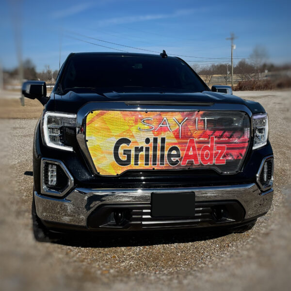 A black pickup truck featuring a Custom Bug Screen: Create Your Own on its grille with the words "say it grille adz.