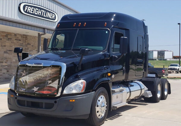 Black freightliner truck parked outside a We The People - Bug Screen dealership.