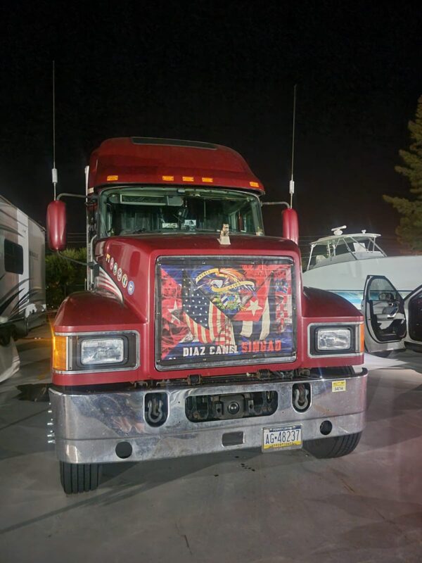 Red semi-custom bug screen parked at night with an american flag-themed eagle graphic on the grill.