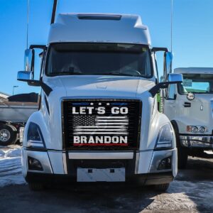 Let's Go Brandon! - Semi Truck Mesh Bug Screen with "let's go brandon" sign on the grille, parked in a lot with snow and other trucks in the background.