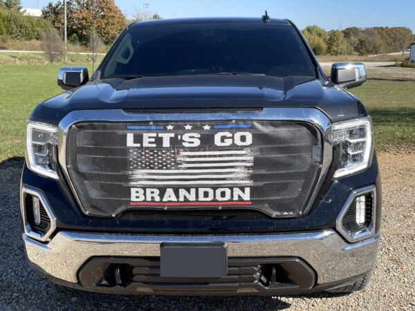 A pickup truck with a Let's Go Brandon!- Pickup/Suv/Van Mesh Bug Screen banner across the front grille.