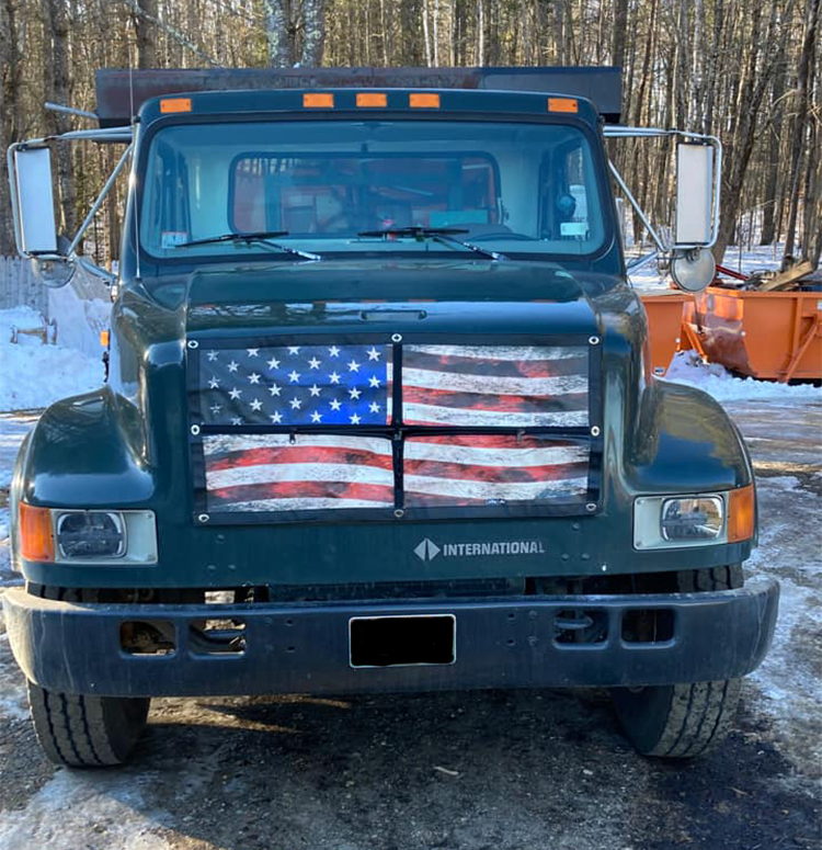A truck with an american flag painted on the front.