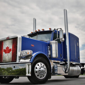 A blue semi-truck with a Canadian Flag - Semi Truck Mesh Bug Screen on the front grille, parked under a cloudy sky.