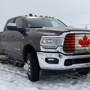 A silver ram 2500 pickup truck with a Canadian Flag- Pickup/Suv/Van Mesh Bug Screen on the grille, parked on a snowy surface.