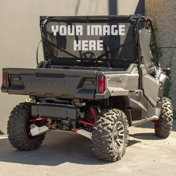 A honda utility terrain vehicle (utv) equipped with off-road tires parked against a wall, displaying a placeholder banner that reads "your image here.