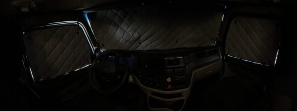 Interior of a semi truck at night with ZenEclipse Premium Window Covers for Semi Trucks and ambient lighting.