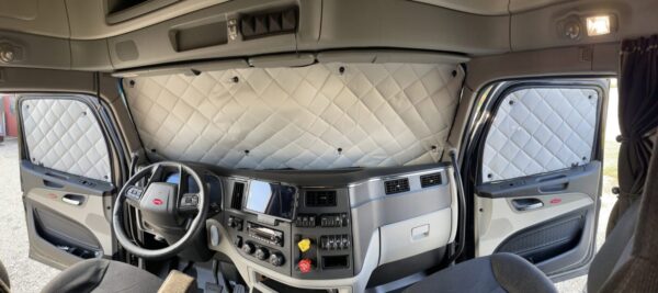 Interior of a modern truck cab with ZenEclipse Premium Window Covers for Semi Trucks behind the seats.