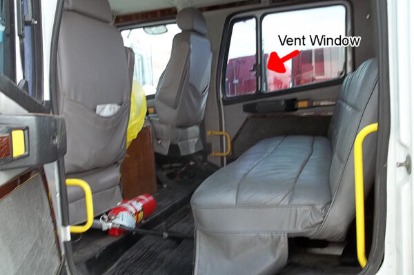 Interior of a vehicle showing seats and a highlighted vent window with ZenEclipse Sleeper Covers for Freightliner.
