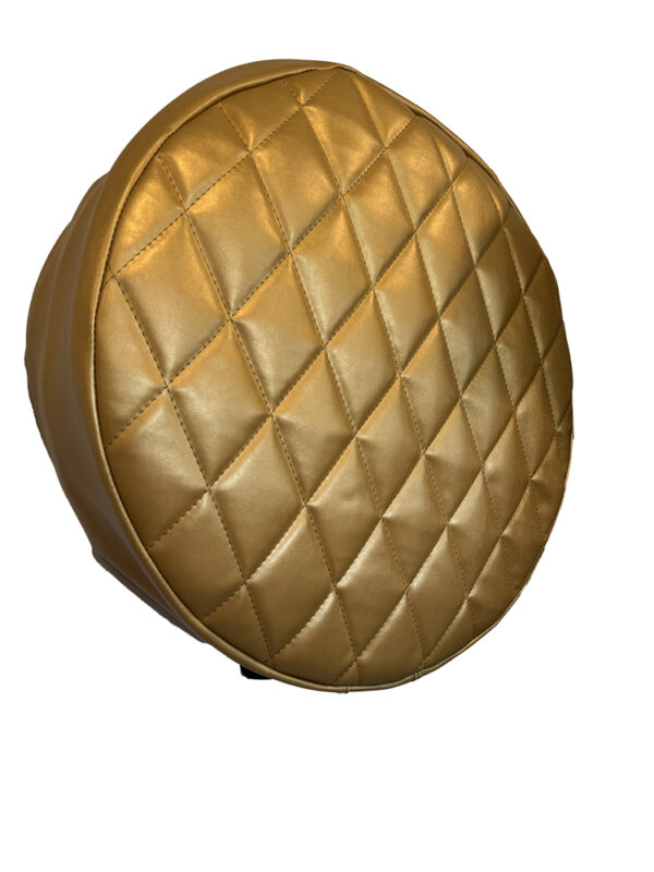 Gold-colored, quilted round pouf against a white background.