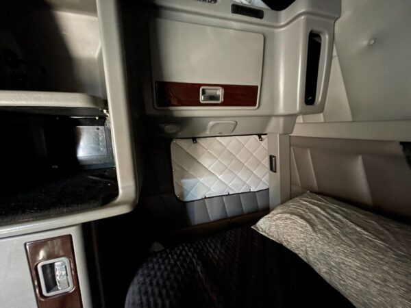 Interior of a truck sleeper cabin showing the sleeping area and storage compartments with ZenEclipse Sleeper Covers for Peterbilt.