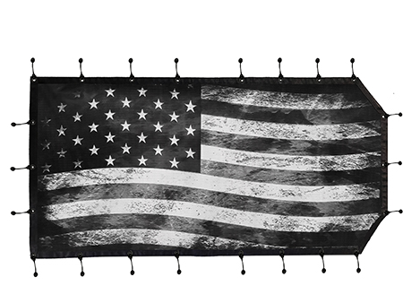 A black and white american flag hanging on the side of a wall.