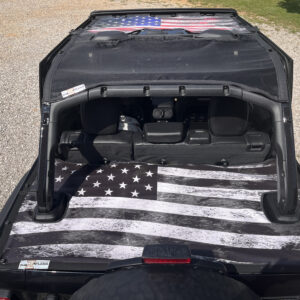 Black jeep with a Junk In The Trunk Cover- Jeep Wranger JL(2018-2023) 4 Door on its spare tire cover, viewed from the rear.