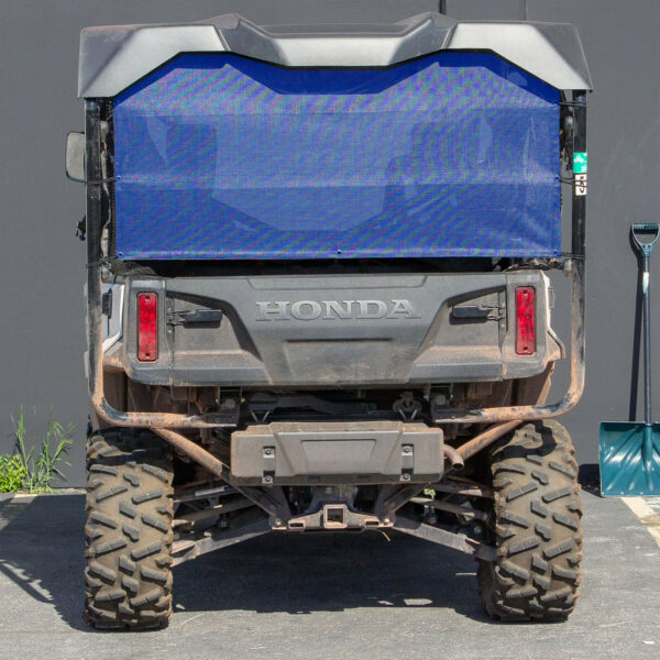 Rear view of a parked honda all-terrain utility vehicle with a mesh cargo bed cover.
