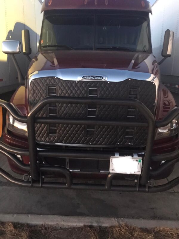 A truck with its front bumper off and the grill on it.