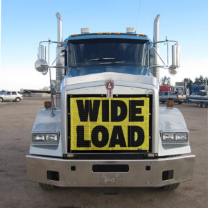 Front view of a white semi-truck with Bug Screen: Wide Load mounted on its grille.